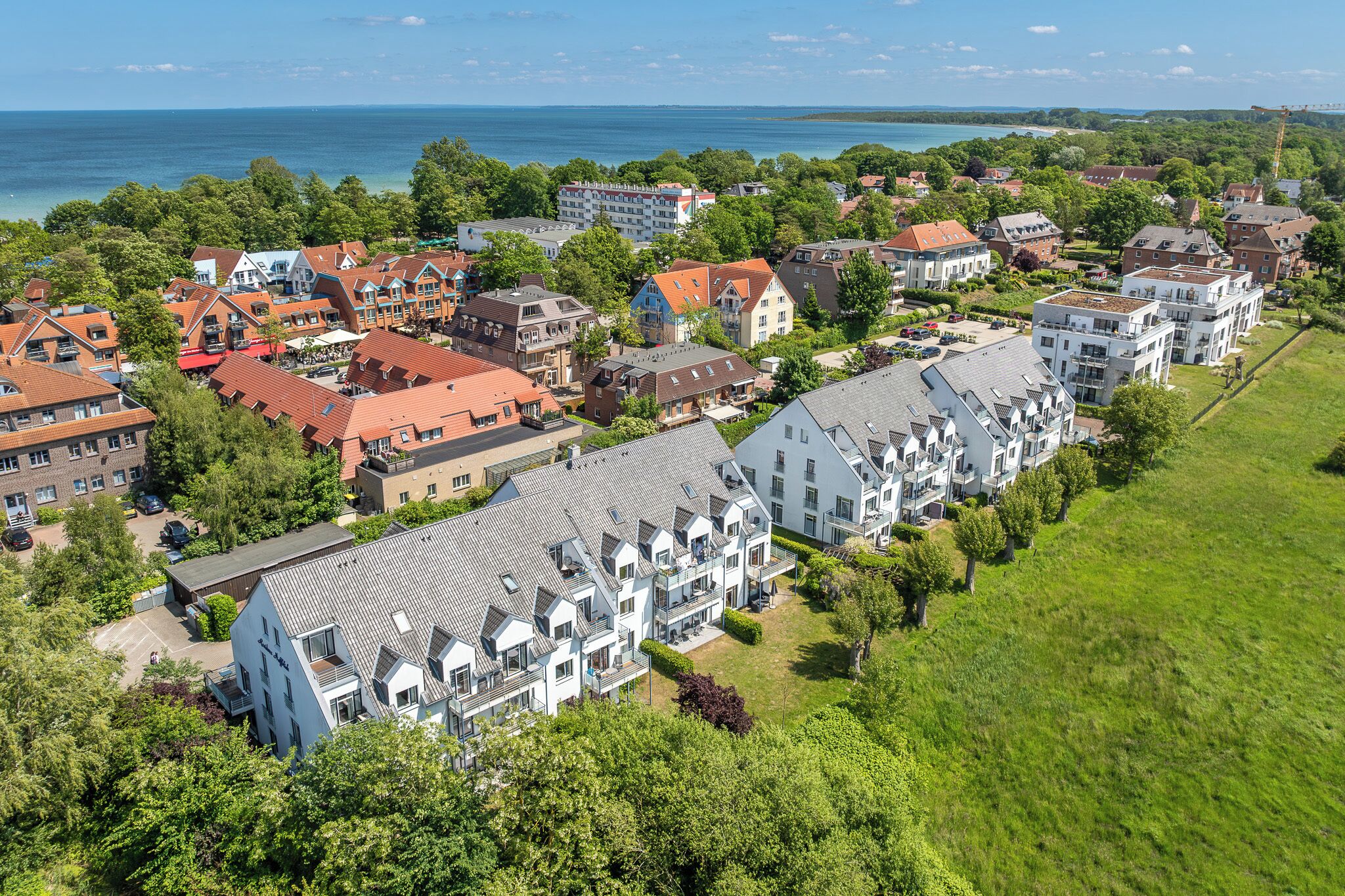 Ett flygbildsbild av ett bostadsområde med hus och en stor byggnad med ett sluttande tak.