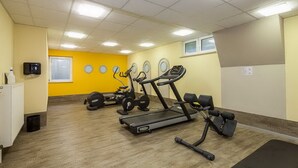 Ein Fitnessstudio mit Laufbändern, Crosstrainern und Gewichte-Bänken.