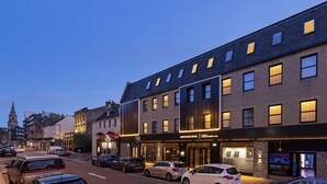 Een hotel met een moderne gevel, grote ramen en een opvallende entree.