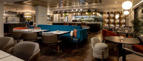 A modern restaurant with a bar area, seating arrangements, and a wooden floor.