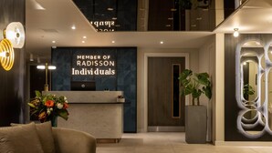 Een moderne receptie met een receptiebalie, een bank en een potplant.