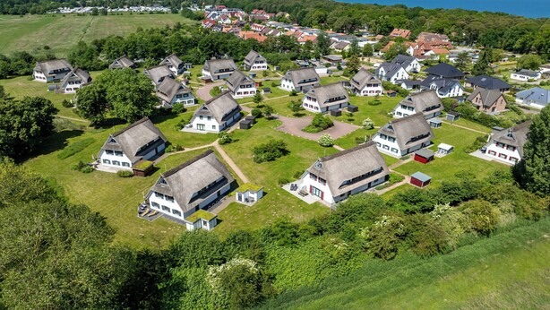 Vue aérienne d’un quartier résidentiel où l’on aperçoit des maisons dotées de toits à forte pente, ainsi qu’un mélange de bâtiments d’un et deux étages.