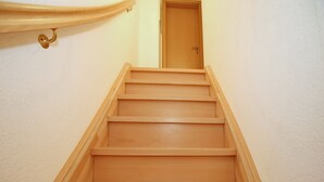 Eine Holztreppe führt zu einer Tür.
