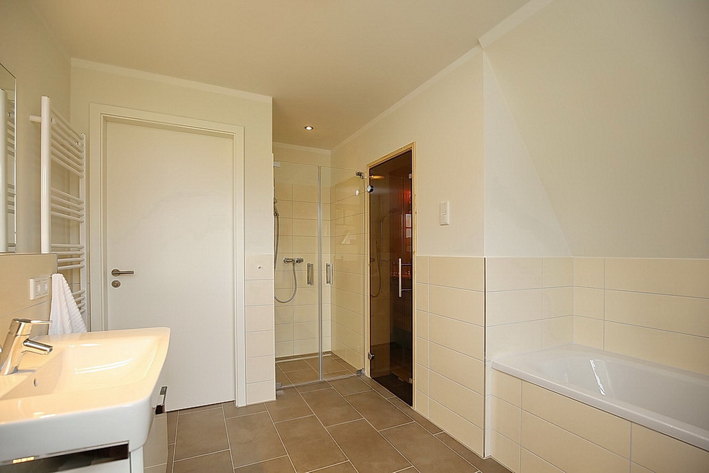 A bathroom with a white sink, a glass shower enclosure, and a bathtub.