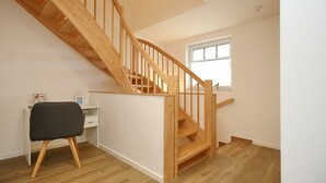 Una escalera con barandillas de madera que da a un descansillo.