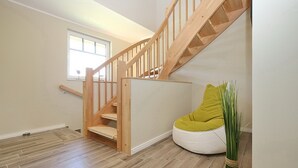 Una escalera con barandillas de madera y una pared blanca.