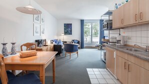 Una cucina moderna con mobili in legno, un piano di lavoro in granito e un'area pranzo con tavolo e sedie.