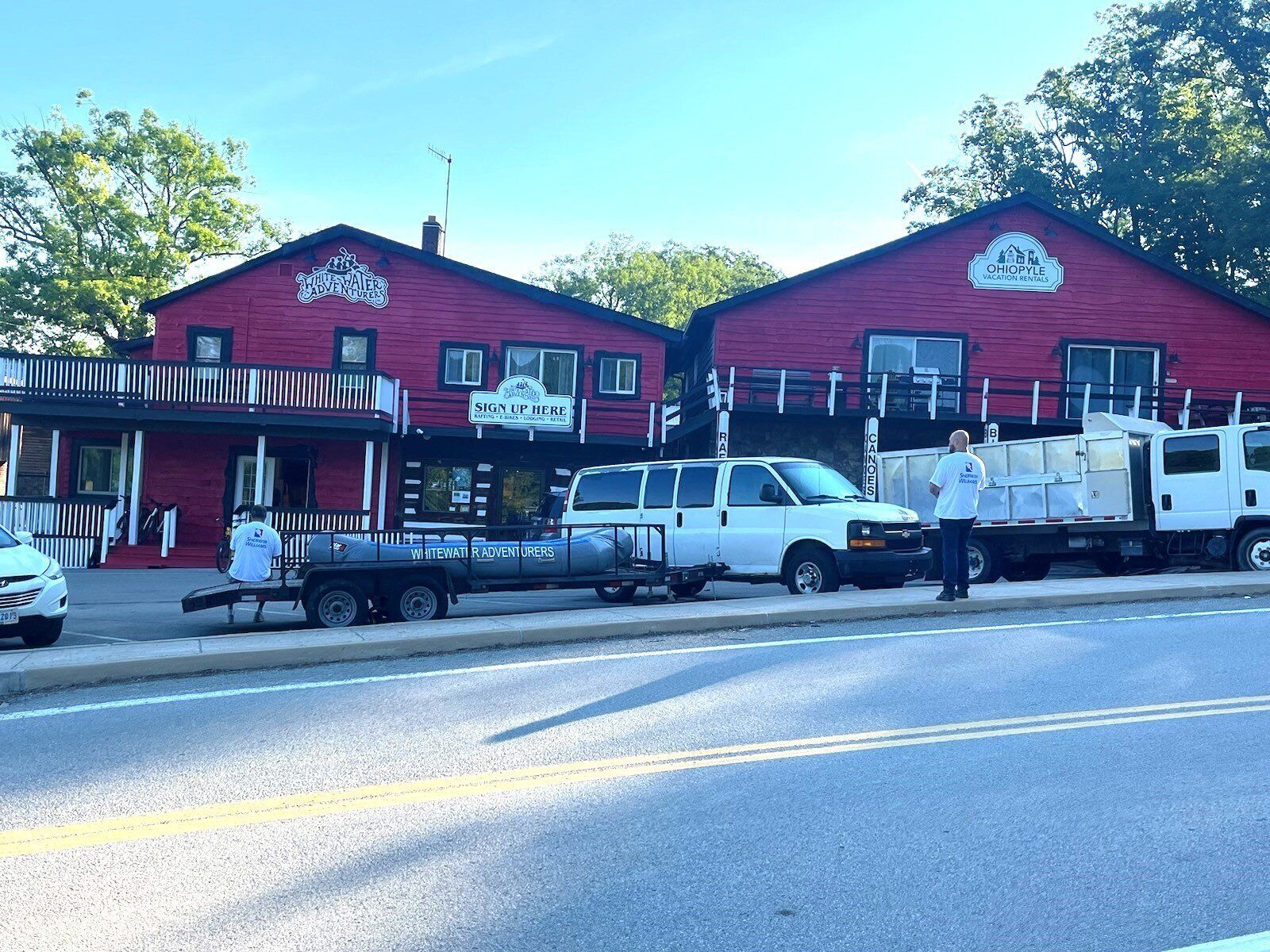 Un edificio rojo con un letrero que dice 'Whitewater Adventurers' y otro letrero para 'OhioPyle Vacation Rentals'.