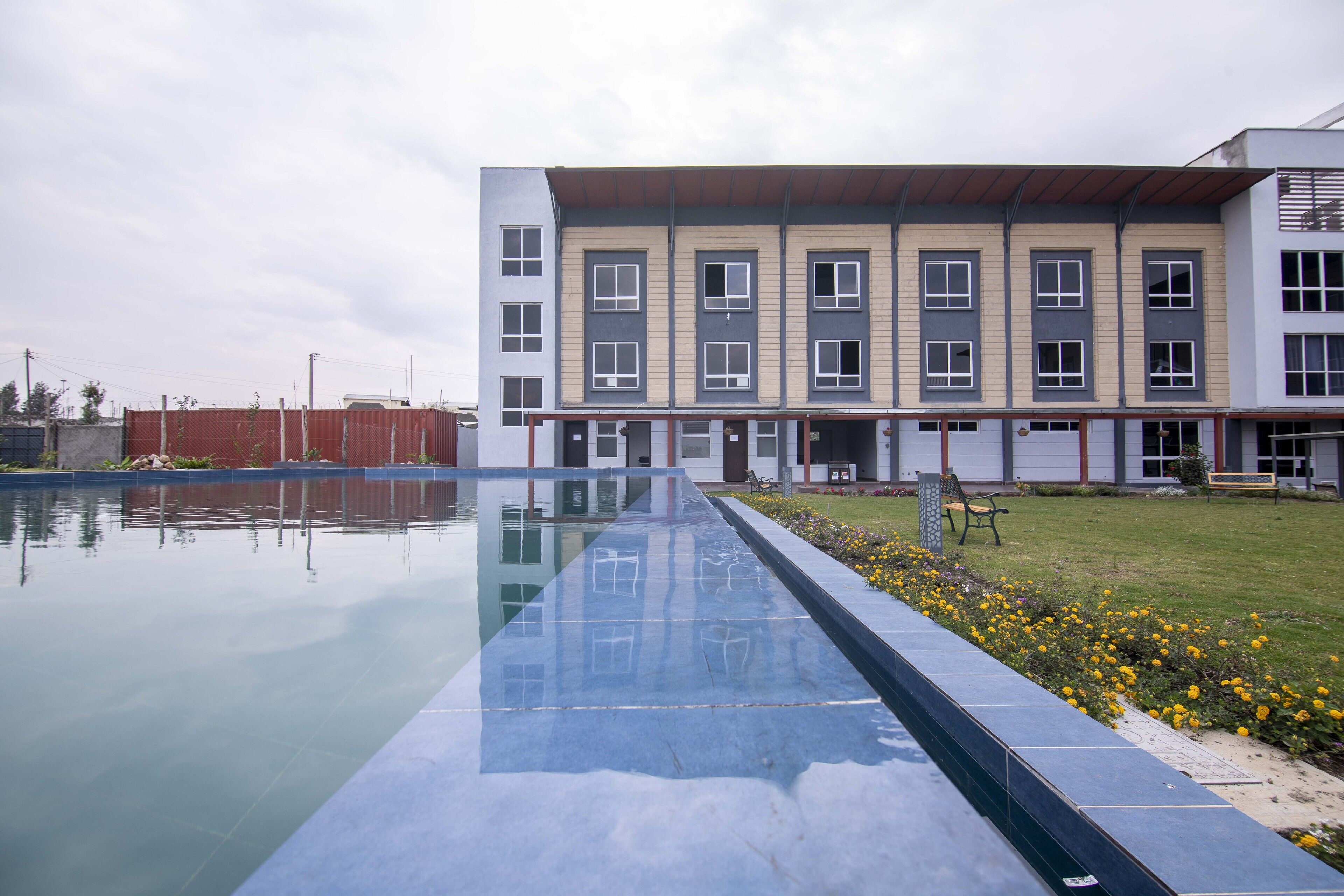A modern building with a swimming pool in front.