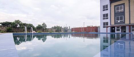 Un bâtiment moderne avec une piscine devant.