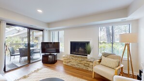 Amplia sala de estar con chimenea, televisor y sofá.
