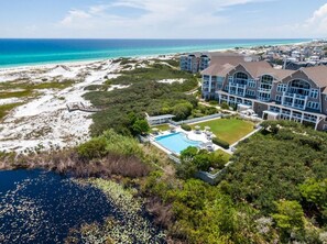 A resort with a large pool, beachfront views, and multiple buildings.