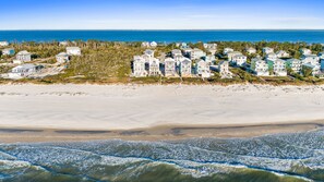 A coastal residential area with beachfront properties, sandy beaches, and ocean waves.