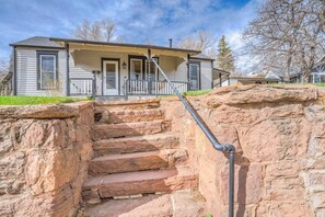 Une maison avec un escalier en pierre menant à un porche.