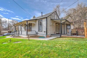 Une maison de plain-pied avec un porche à l’avant, un patio couvert et un petit jardin devant.