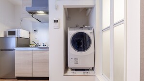 Una cocina compacta con microondas, refrigerador y lavadora.