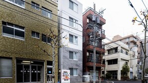 Un edificio de varios pisos con una combinación de fachadas de ladrillo y diseño moderno, que cuenta con una máquina expendedora en la planta baja.