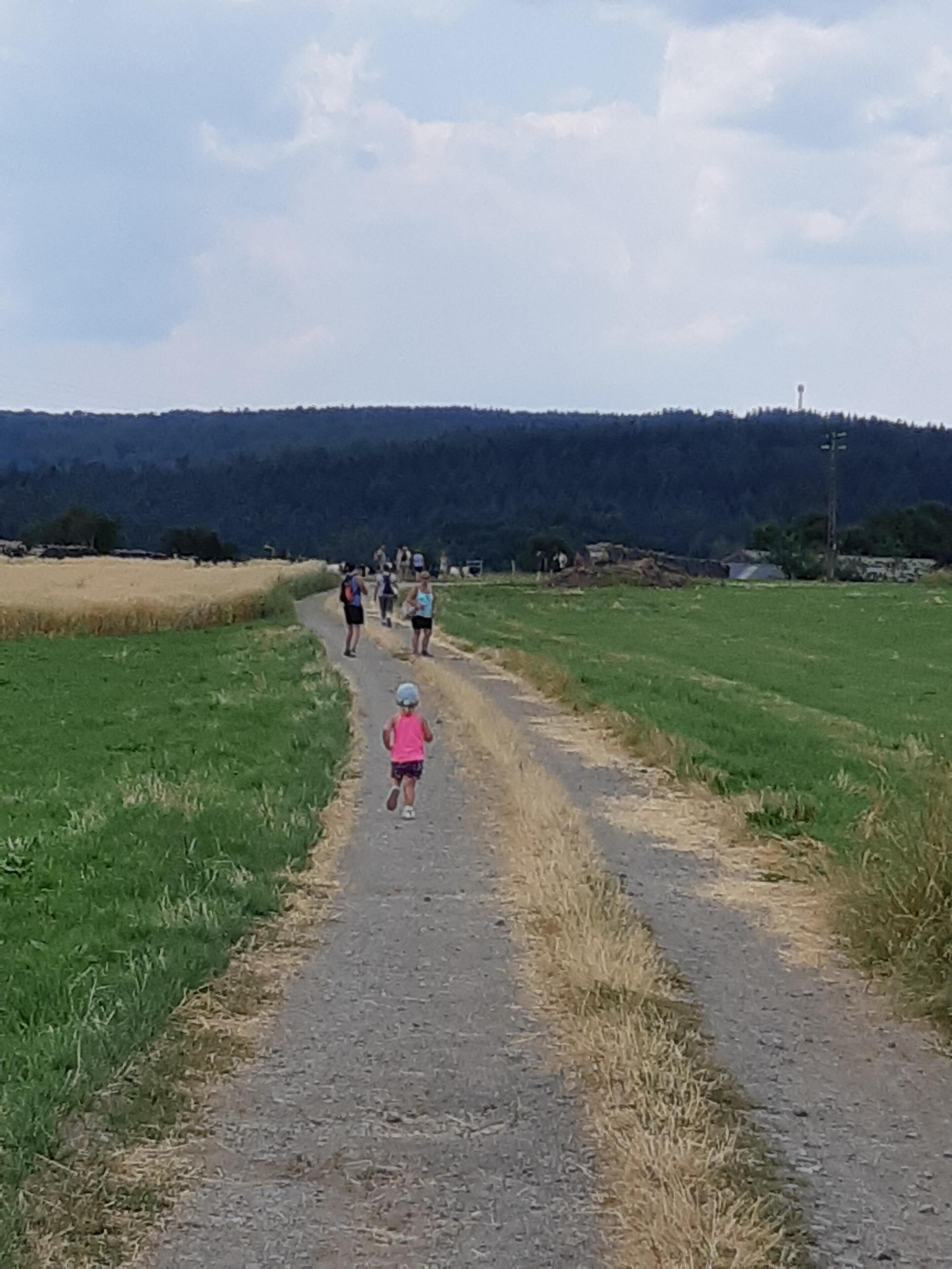 Un sentier de campagne où l’on voit des gens se promener.