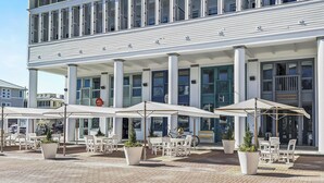 Un bâtiment à deux étages doté d’une entrée centrale, d’un espace extérieur aménagé avec des parasols et d’une enseigne bien visible indiquant « 25 Central Square ».