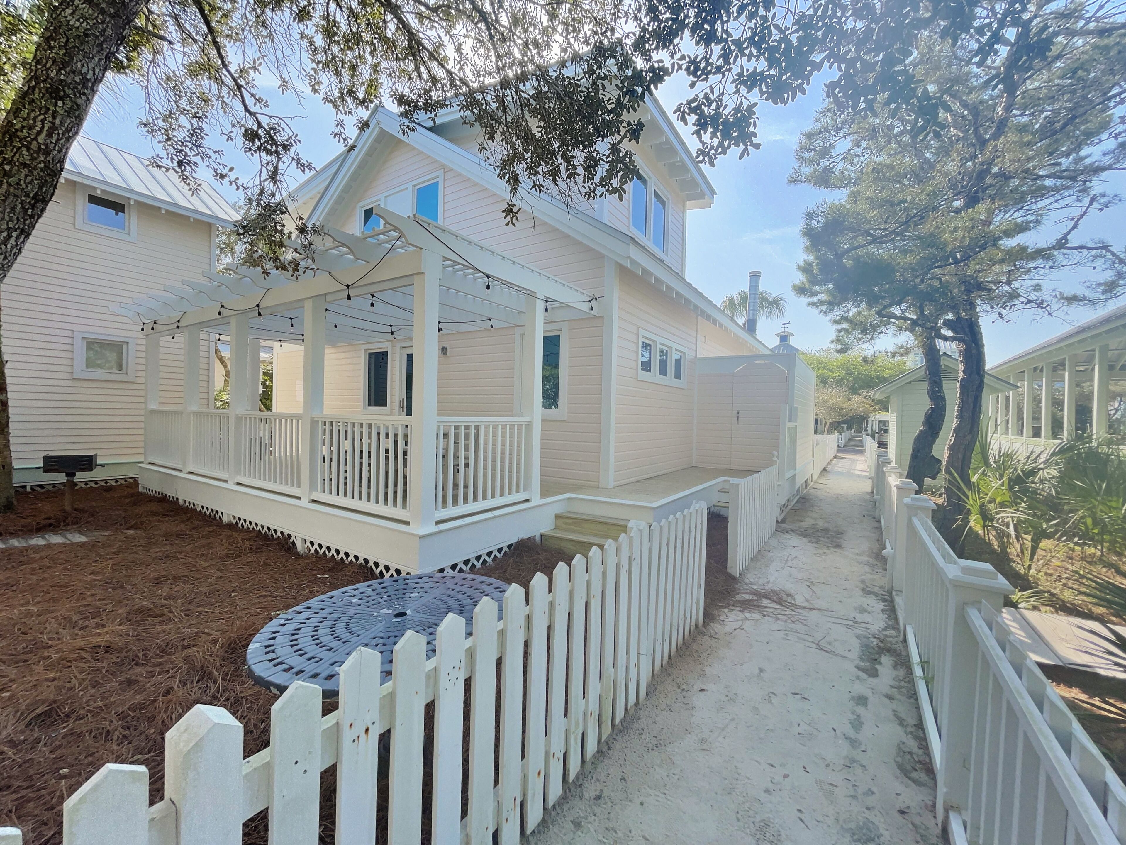 A two-story house with a covered porch and a fenced yard.