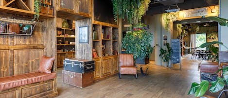A rustic interior with wooden shelves, leather seating, and hanging plants.