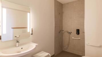 Ein Badezimmer mit Waschbecken, Spiegel, Toilette und Dusche.