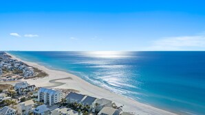 A coastal hotel with multiple buildings, a beach, and a view of the ocean.