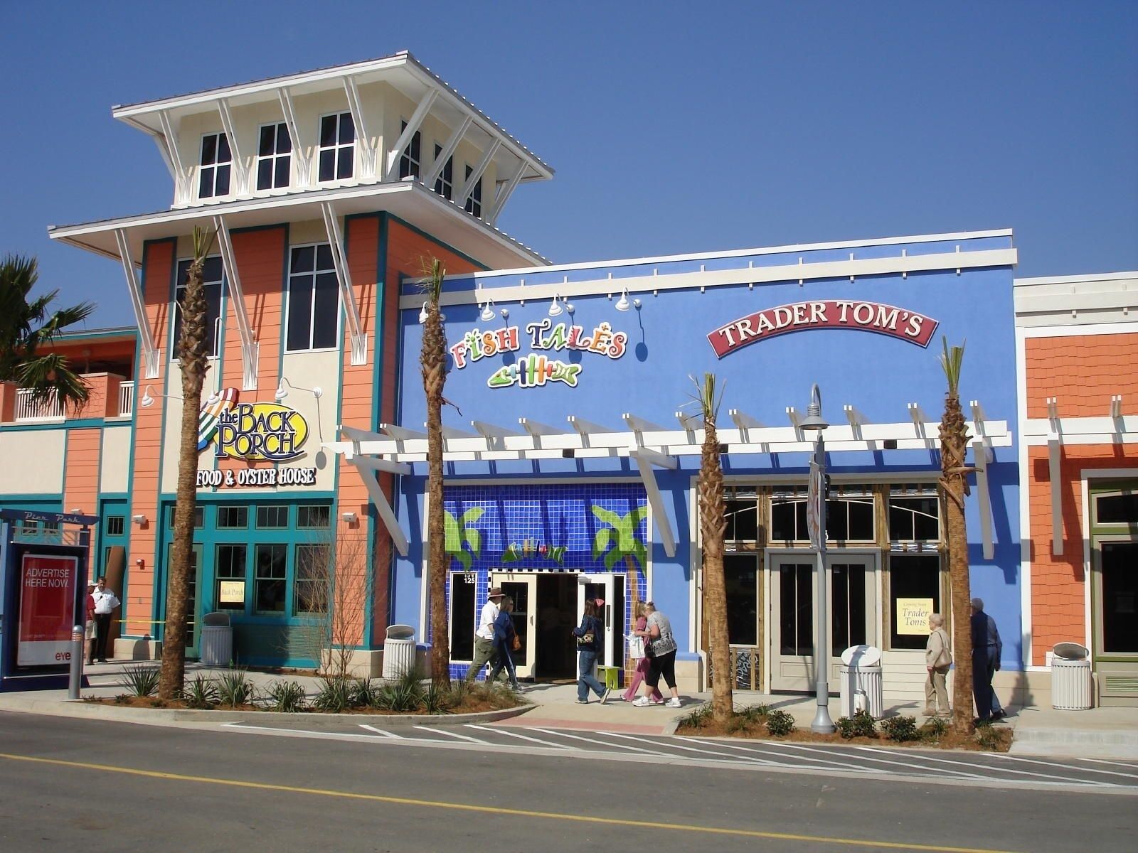 Un bâtiment à la façade bleue, une enseigne indiquant « Fish Tales Aquarium » et une autre indiquant « Trader Tom's ».
