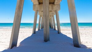 A concrete pier structure extending into a sandy beach with clear blue water. - Sea-horsey 3 Bedroom Condo by RedAwning (Panama City Beach)