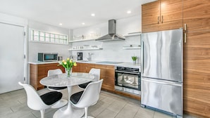 A modern kitchen with a central island, stainless steel appliances, and wooden cabinets. - Posh Condo in Ocotillo Lodge in South PS (Palm Springs)