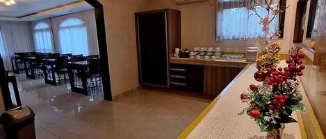 Una habitación de hotel con comedor, cocina y pasillo.