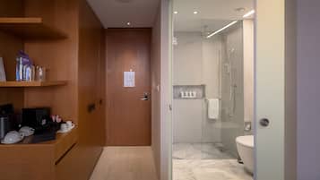 Et moderne badeværelse med brusekabine i glas, toilet og en marmorbelagt gulv.