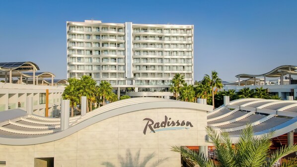 A modern hotel with a curved facade, multiple balconies, and a prominent 'Radisson' sign.