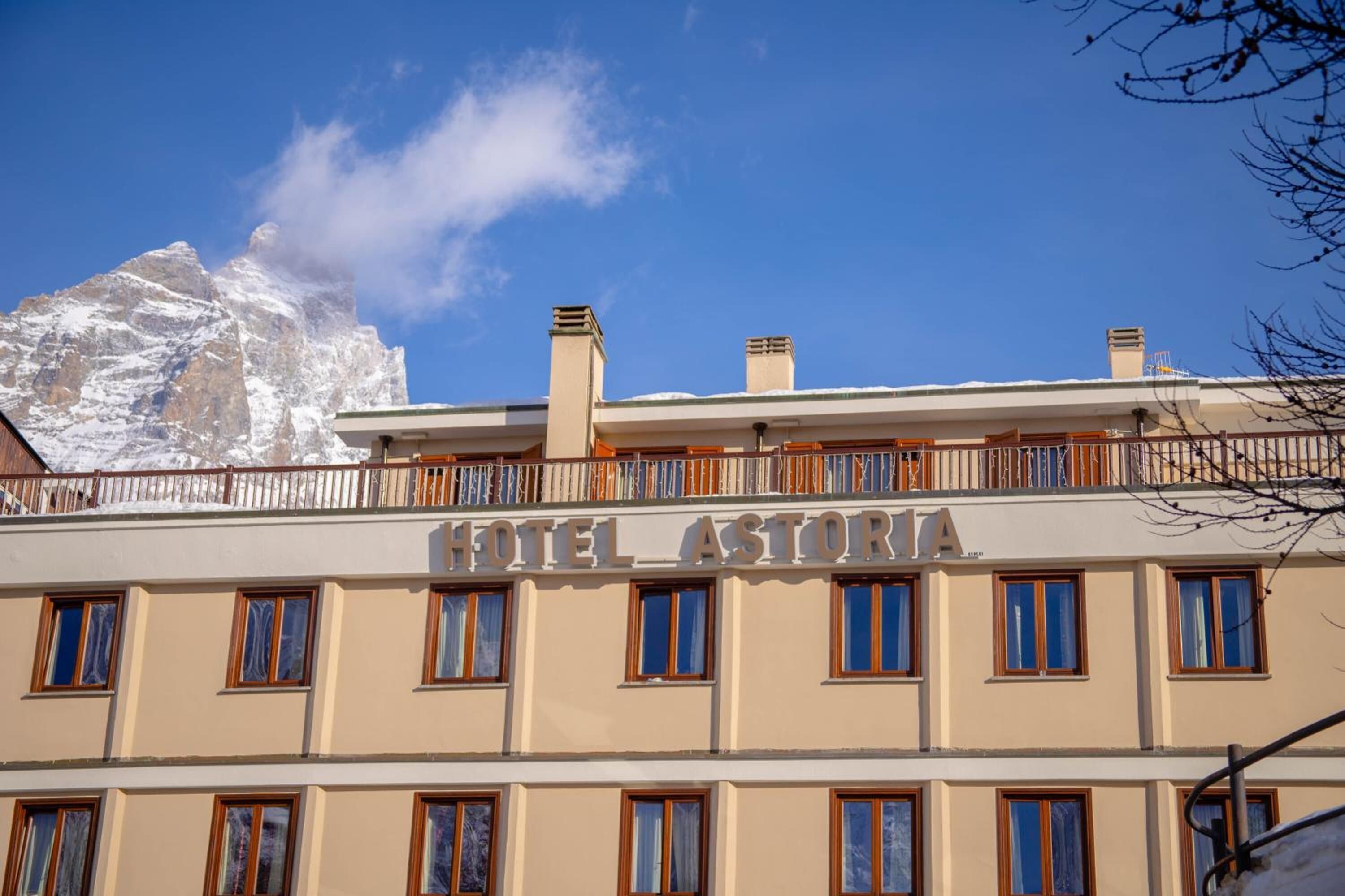 Un hotel llamado "HOTEL ASTORIA" con un balcón y varias ventanas.