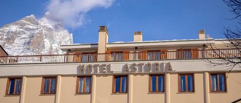 Un hotel llamado "HOTEL ASTORIA" con un balcón y varias ventanas.