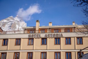 Un hotel llamado "HOTEL ASTORIA" con un balcón y varias ventanas.