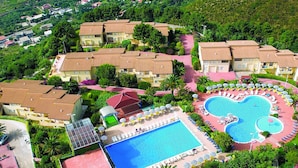An aerial view of a resort with multiple buildings, a large central pool, and smaller pools. - Tropea Mare Pace Club (Tropea)