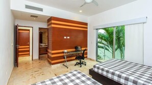 Une chambre d’hôtel avec deux lits, un bureau et une vue sur la verdure.