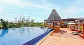 Una piscina con cubierta de madera y una estructura de techo de paja.