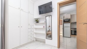 A compact kitchen with white cabinets, a built-in oven, and a refrigerator. - Soso's Garden Villa with Private Pool (Zakynthos)