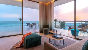 A modern room with a large glass door leading to a balcony overlooking the ocean. - Hyatt Regency Taghazout  (Taghazout)
