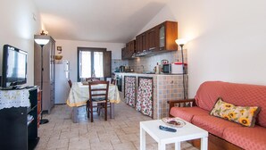 Un espacio habitable compacto con comedor, kitchenette y sofá.