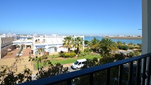 A coastal view with a white building labeled 'NAUTICA', palm trees, and a clear blue sky. - EL FARO 60 - One Bedroom Apartment, Sleeps 3 (Punta del moral)