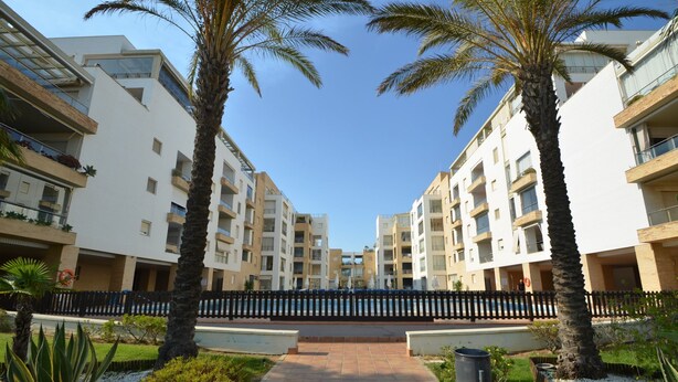 A modern apartment complex with multiple floors, balconies, and a central walkway. - Espigón Central 11 - One Bedroom Apartment, Sleeps 3 (Punta del moral)