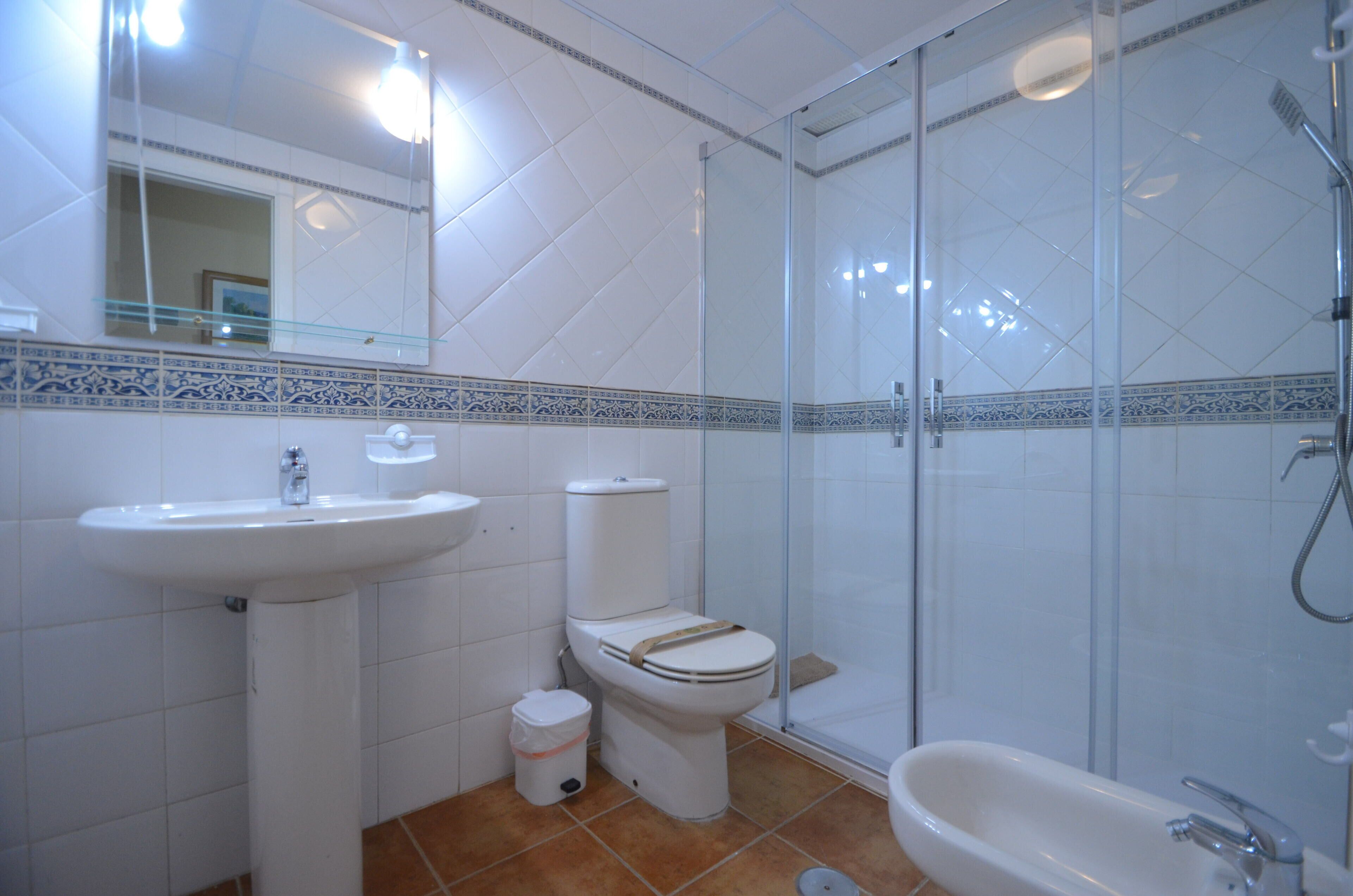 A bathroom with a sink, toilet, shower, and bathtub.