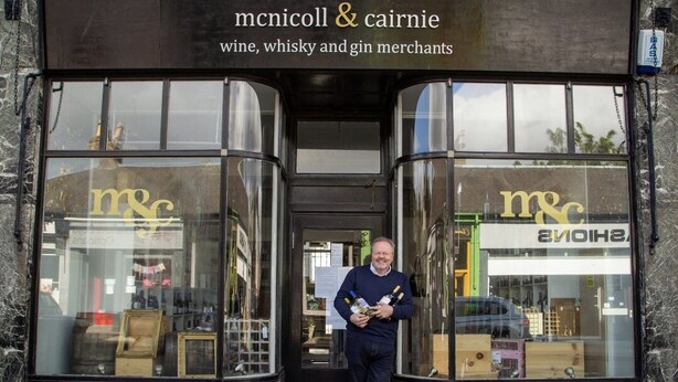 The entrance to a wine, whisky, and gin shop with large glass windows and a marble facade. - A luxurious Victorian mansion garden apartment (Broughty Ferry)