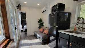 Una cocina moderna con un refrigerador negro, un lavamanos y una ventana.