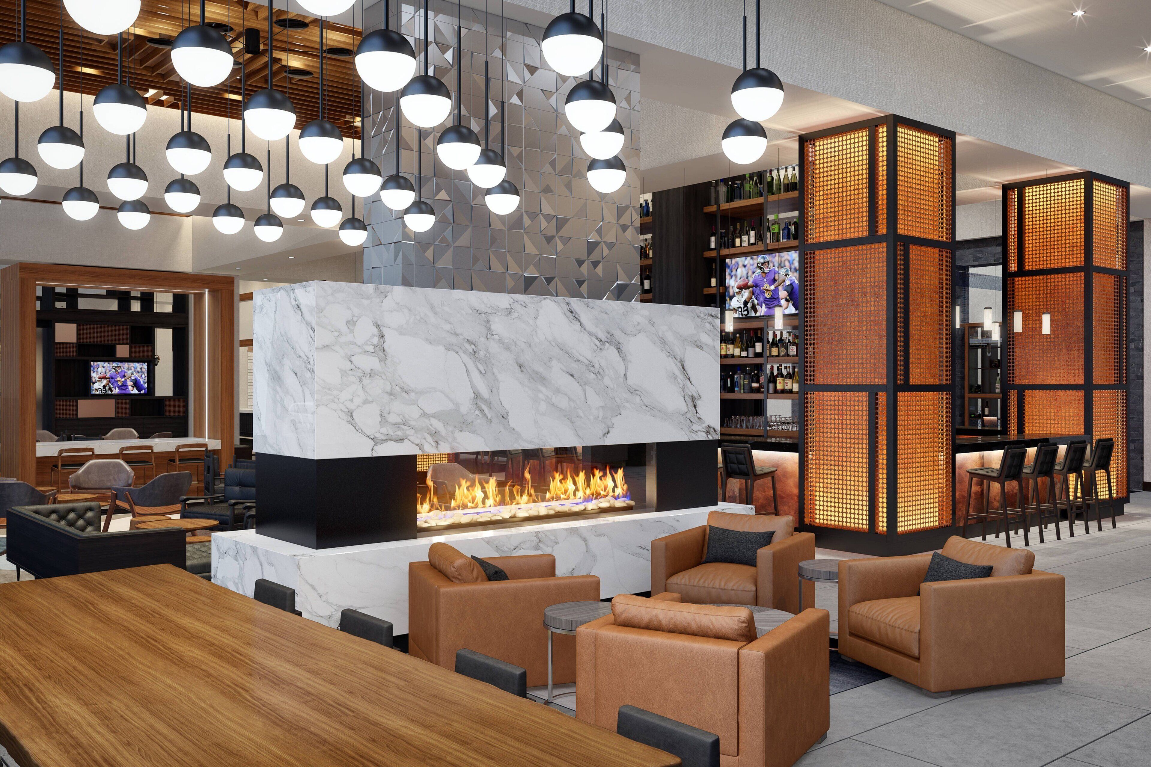 A modern lounge area with a marble fireplace, leather seating, and a bar area with shelves of bottles.