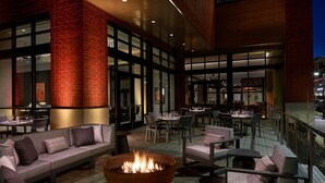An outdoor seating area with a fire pit, cushioned seating, and tables. - Marriott Owings Mills Metro Centre (Owings Mills)