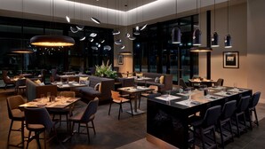 A modern hotel lobby with a mix of seating areas, including sofas and tables, and a large conference table. - Marriott Owings Mills Metro Centre (Owings Mills)